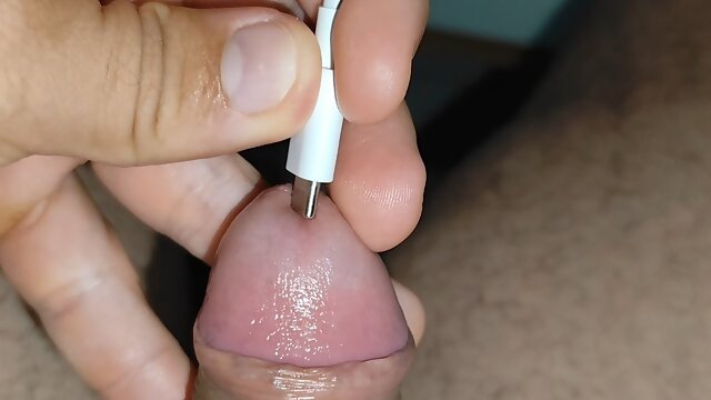 High-voltage charging plugged into the boy's cock makes him horny.