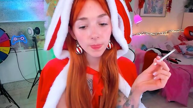 Red-haired Santas helper smoking seductively