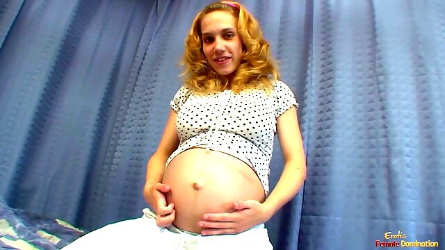 Knocked up blonde chick pummeling her shaved pussy with a glass dildo on the bed