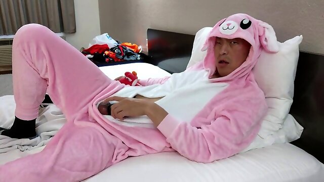 Steamy Asian model Cockyrocky shows off in a cute pink onesie and dark boxer trunks at a cheap motel