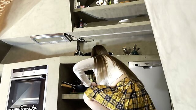 Curvy Norwegian brunette milf in a short skirt teases bare pussy and thick thighs in the kitchen with no panties during an upskirt striptease