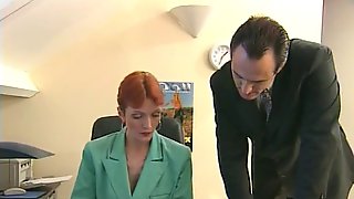 Redheaded older secretary sucks boss's cock at her desk
