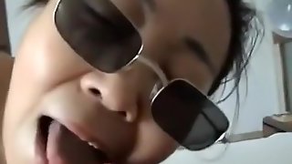 Asian girl with sunglasses sucks cock, while getting fingered.