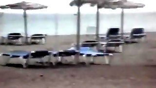 Milf sucks and jerks her mans cock at a beach on vacation