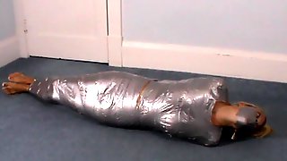 Blonde girl wrapped in duct tape struggles