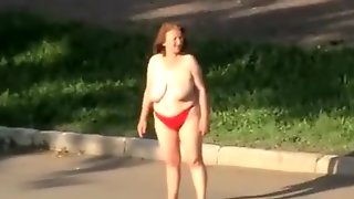 Drunk older woman walks topless