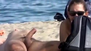 Wife strokes his half hard penis at the beach