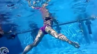 Underwater view with skinny dipping nudist women and men