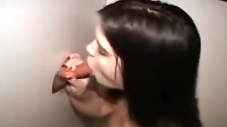 Gloryhole brunette sucks off strangers