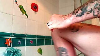 Muscular tattooed guy takes hot shower after the gym
