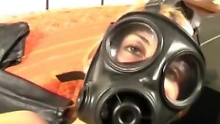 Blonde in gas mask on bed