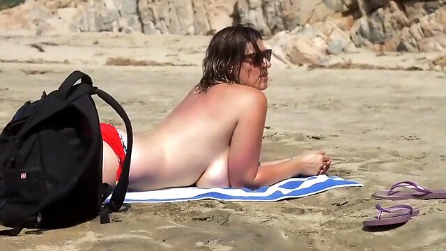 Busty milf on beach showing big tits