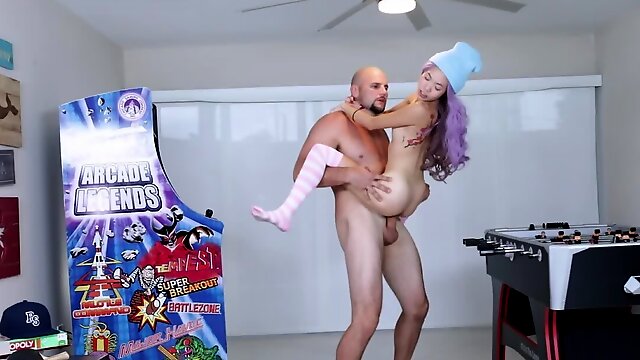 Bald bruiser impales skinny Asian girl near arcade game