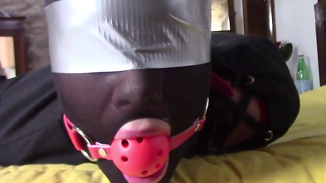 Slave girl lays on the floor wearing a ball-gag and high heels