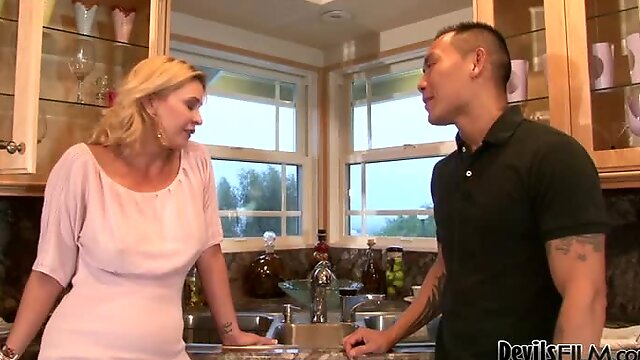 Tattooed Asian dude fucks a hot blonde milf in the kitchen