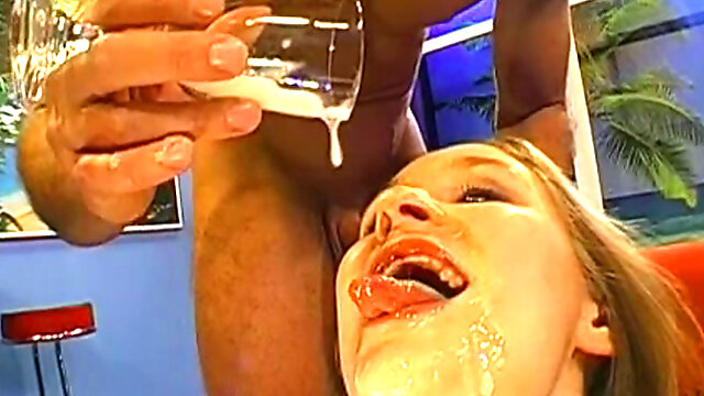 Busty blonde swallows a glass of jizz