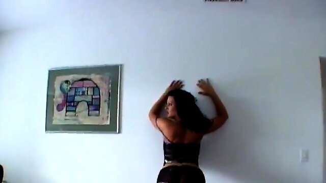 Solo model leans on the wall in order to expose her beautiful ass