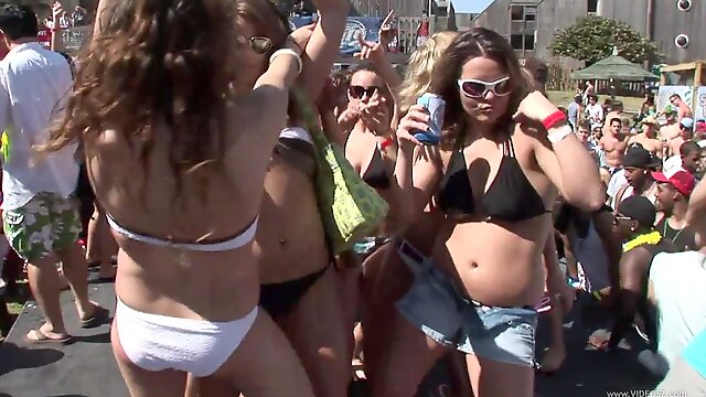 Sensual babes in bikinis and shorts with sexy bodies dancing at an outdoor party