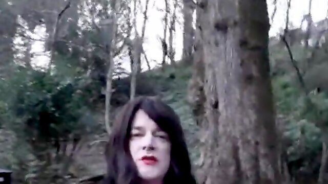 Crossdresser dressed in a brief leather miniskirt ambling in the park in Waterfoot Lancashire