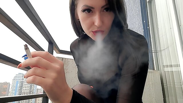 Dominatrix smokes sexy and blows smoke at you
