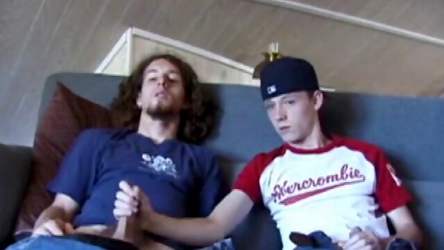 We join EJ and Adam with their dicks out and pants down. Curious, EJ leans over and starts stroking Adams cock. Adam helps EJ too, getting down on him. EJ wants to try sucking his cock, so he takes Adams cock in her mouth.