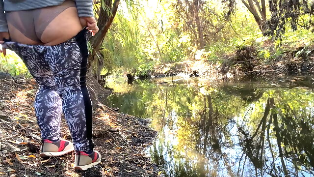 MILF dressed in leggings pissing in the river