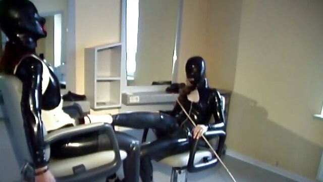 Tied to the barber chair, she is fingered hard in her latex suit