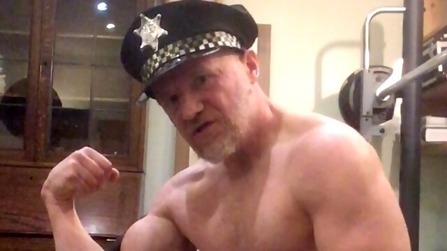 Muscle worship bodybuilder cop turning himself on flexing biceps and stroking huge cock.