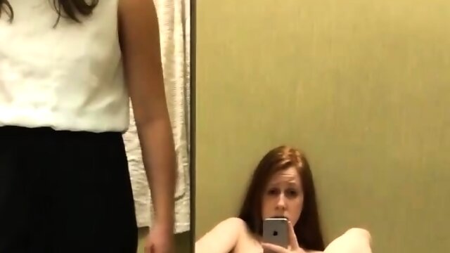 Young amateur redhead fingering her pussy in a dressing room