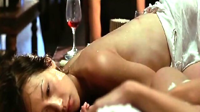 Maggie Q making out with a guy in the ocean and removing