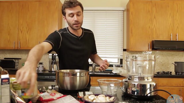 Handsome guy having fun while making dinner for his wife