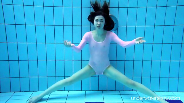 Sexy red haired swimming babe Roxalana Cheh is stripping under the water