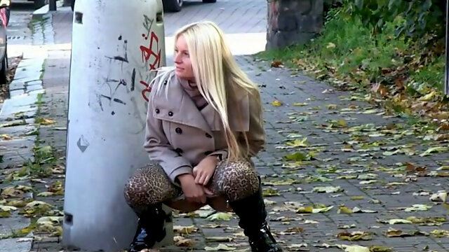 Lusty blond MILF in autumn coat pisses in the mid of the street