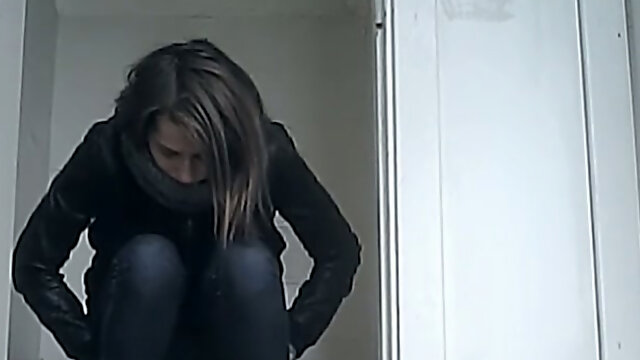 White young chick in leather jacket and jeans filmed in the toilet