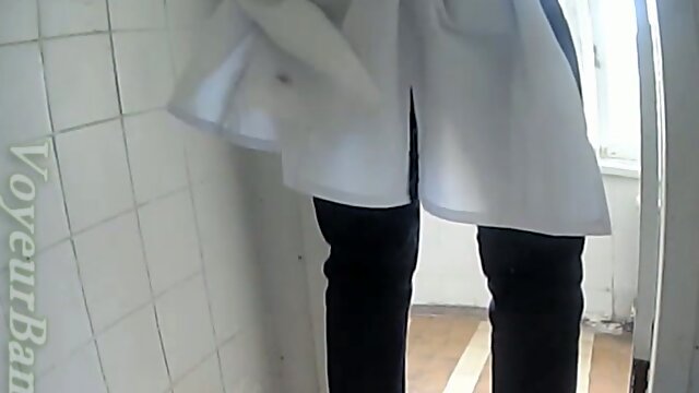 White lady in black pants and white blouse pissing in the toilet