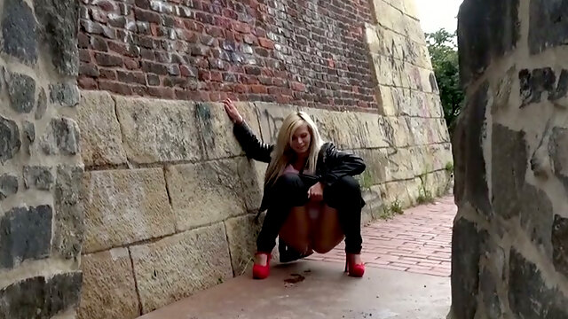 Bright blonde pulls down her pants to pee near the old city wall