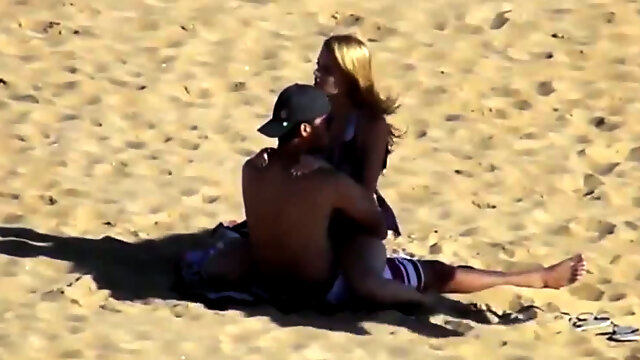 Hidden cam scene with a couple banging in the cowgirl pose on a beach