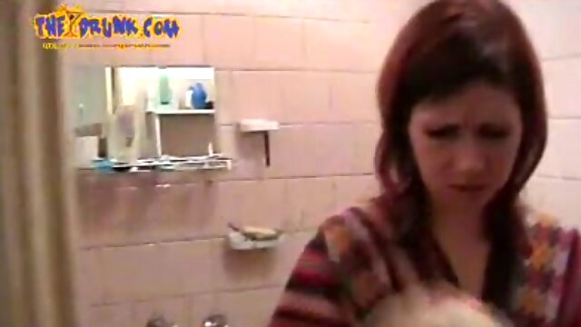 Margo washes her face in a bathroom and flashes her pussy