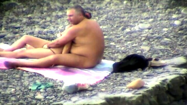 Pussy fingering of a MILF in a public nude beach