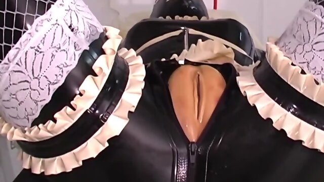 One girl is bound in latex as the other one strap-on fucks her