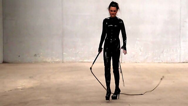 The Goddess Obsidian Wields Her Bullwhips Ominously In Her Latex Catsuit