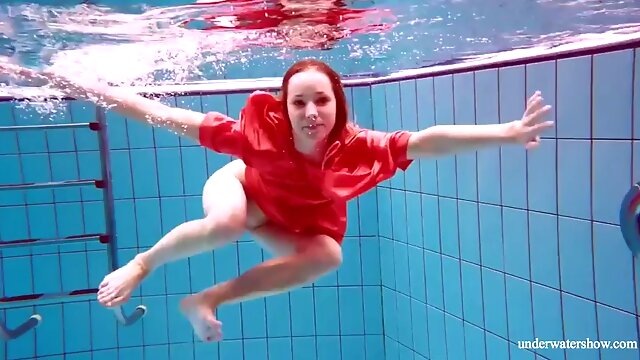 Pretty girl in red sexy open dress swimming