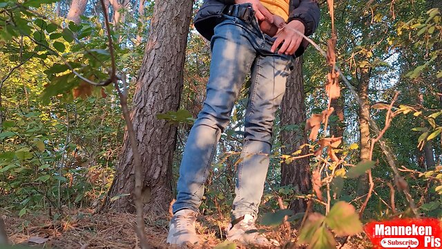 Guy pissing in the forest under a tree