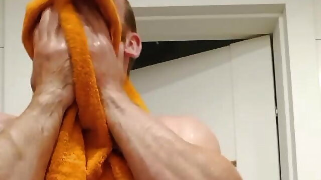 Muscular fitness bodybuilder is cleaning body taking shower and doing muscle worship