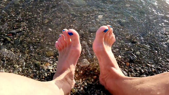 On public beach I sit on the shore dressed in cutoffs and t-t-shirt and drenching my soles in the river ...