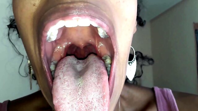 Ebony girl opens her mouth wide and pulls out long tongue