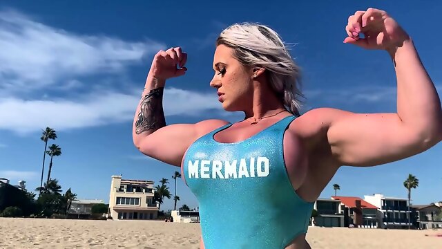 Muscle blonde milf flaunts amazing curves on the beach