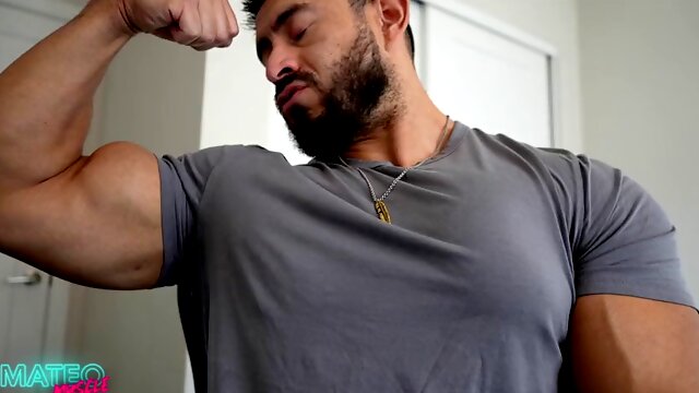 Muscular handsome guy flexes his chest in a tight shirt