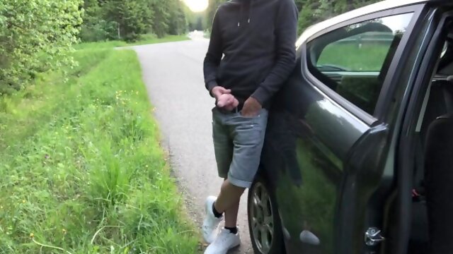 Guy jerks off his curved cock on the side of the road